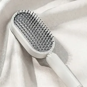Minimalist creamy white massage hair brush for women on elegant silk background