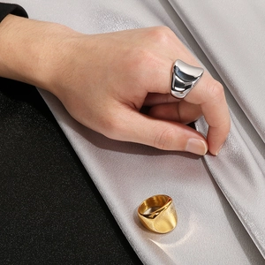 Detailed shot of 18K gold and silver chunky stainless steel rings on a silk background