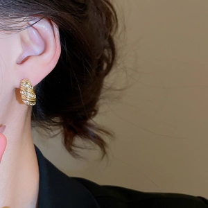 Close-up of 18K gold-plated twisted hoop earrings with micro-set sparkling zircons