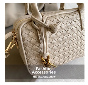 Close-up of beige hand-woven leather texture and gold metal zipper hardware on bag