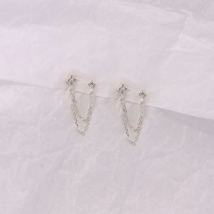Detail of 925 sterling silver tassel earrings with geometric zircon inlay on pink backdrop