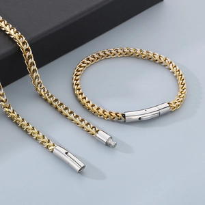 Détail du collier et bracelet chaîne épi en acier inoxydable bicolore or et argent brillant