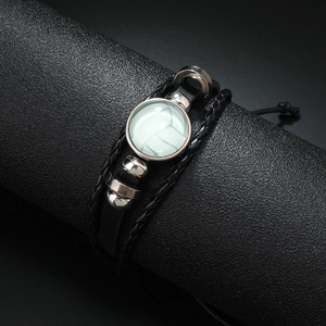 Détail du bracelet de volley-ball en cuir tressé avec perles métalliques sur support noir