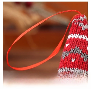 Close-up of red lanyard and detailed knit texture of the forest gnome Christmas ornament