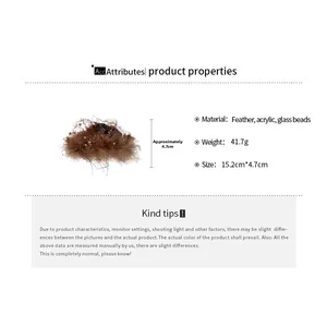 Detail showing brown feather hair clip dimensions of 15.2cm with glass bead accents