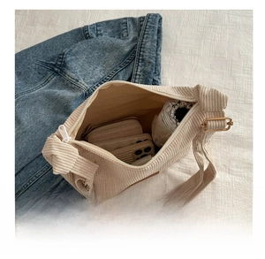 Detail view of large capacity corduroy tote bag showing interior storage for daily items