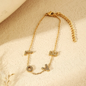 Detailed macro shot of a gold-plated LOVE letter bracelet set with sparkling zircons