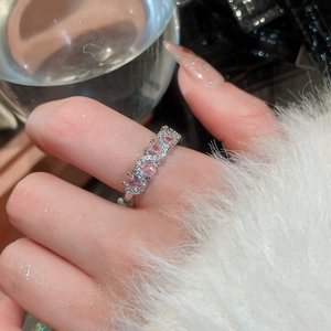 Detail of silver wavy ring featuring sparkling pink cubic zirconia on a female finger