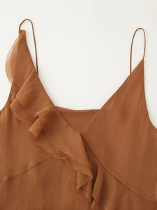 Détail d'un top en mousseline plissée marron avec volants et fines bretelles