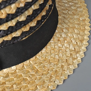 Detail der natürlichen Strohwebstruktur mit schwarzem Band an diesem eleganten Sonnenhut