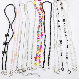 Detail showing various beaded phone charms with pearls, acrylic bears, and metal heart pendants