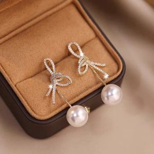 Elegant gold knot earrings with shimmering zircons and hanging white round pearls