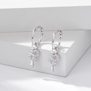 Macro shot of silver snake earrings with pavé cubic zirconia on geometric stone