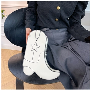 Gros plan d'un sac à main créatif en forme de botte blanche avec détail d'étoile