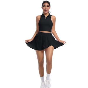 Détail d'un ensemble de sport noir avec haut polo sans manches et jupe plissée à taille haute