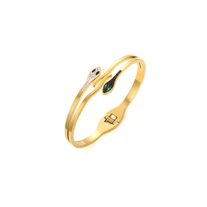 Detailed view of snake head bracelet with gold finish and sparkling crystal pavé settings