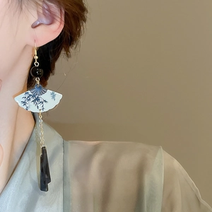 Détail de boucles d'oreilles éventail de style chinois avec motif bambou et glands