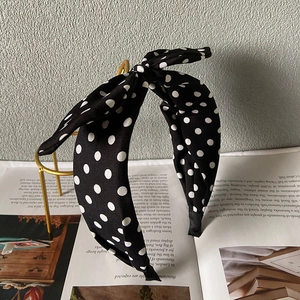 Detailansicht eines Vintage-Haarreifens in Schwarz mit weißen Punkten und großer Schleife
