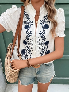 White V-neck shirt with blue floral embroidery and button-down front for women