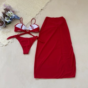 Vue à plat de l'ensemble bikini rouge 3 pièces avec haut licou, bas et jupe en maille fine
