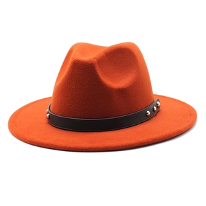 Detailed macro view of burnt orange wool fedora with black studded leather band