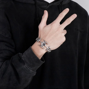 Macro detail of industrial silver punk bracelet with sharp geometric links on male wrist
