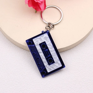 Blue and white cassette tape keychain with 1990 FRIEND text on minimalist beige base