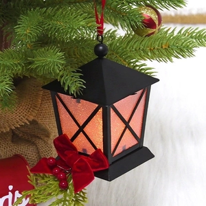 Golden Christmas lantern hanging on tree with red ribbon bow and berry details