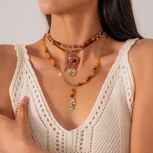 Bohemian multi-layer necklace with wooden beads, coin charms and a golden leaf pendant