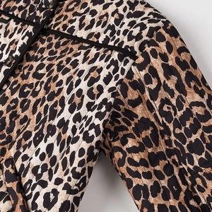 Close-up of leopard print quilted jacket featuring black piping and dark button details