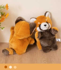 Detail of cute orange red panda plush toy with striped fluffy tail on wood surface