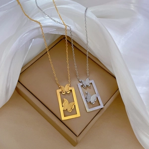 Detail of gold and silver butterfly pendant necklaces on a silk beige jewelry box