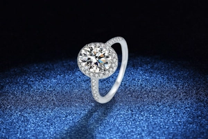 Macro shot of 1 carat moissanite ring with halo setting on sparkling blue background