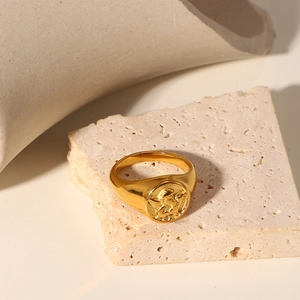 Detail of vintage 18k gold plated angel relief on a round signet ring with retro styling