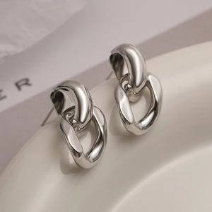 Polished silver double-link geometric chain stud earrings on a white minimalist background