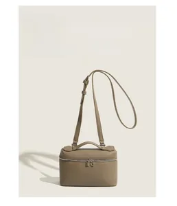 Detailed macro view of taupe lychee leather texture and silver zipper on the box bag