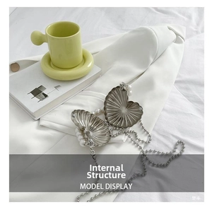 Detail showing internal compartment of heart shaped silver metal clutch with pearl trim