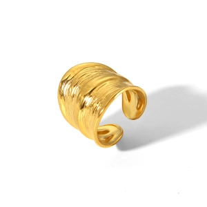 Macro shot of gold-plated wide textured ring with unique hammered metal surface detail