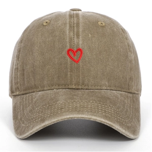 Primo piano del berretto da baseball vintage in cotone kaki con ricamo a cuore rosso