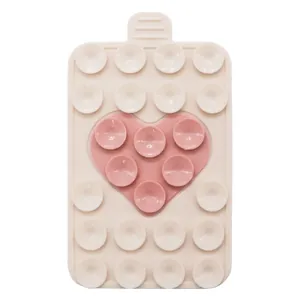 Detailed view of dual-color silicone suction pad with pink heart pattern and hanging hole