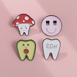 Detailed macro view of four dental enamel pins including a tooth with RDH lettering