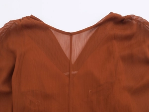 Detail des terrakottafarbenen V-Ausschnitt-Kleids mit feinem Falten-Chiffon-Gewebe