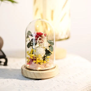 Detail of eternal rose arrangement with LED lights and wood base in dome