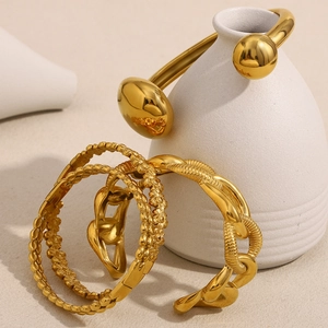 Détail de quatre bracelets en acier inoxydable plaqué or 18 carats avec chaînes et fleurs
