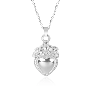 Macro shot of silver heart pendant featuring floral details on a delicate steel chain