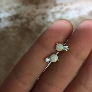 Macro view of gold S925 silver stud earrings featuring round opal and cubic zirconia