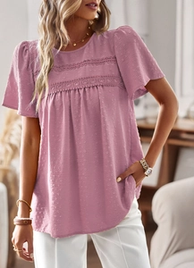 Close-up of pink round neck blouse with textured fabric and lace stitching detail