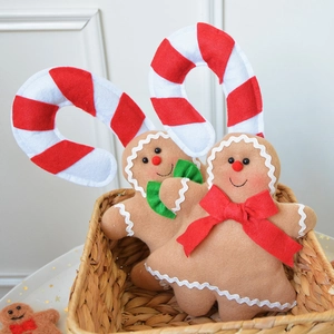 Plush gingerbread man Christmas ornaments with candy cane headbands in a basket