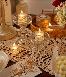 Close-up of glass pillar candle holders with warm LED electronic tea light candles