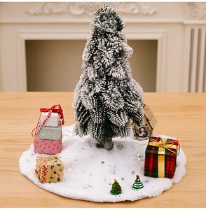 Close-up of white plush Christmas tree skirt with silver embroidered snowflakes